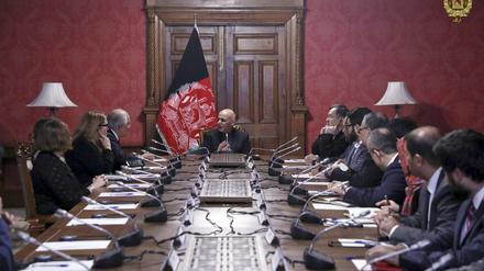 Aschraf Ghani (M) spricht mit Zalmay Khalilzad, Leiter der US-amerikanischen Delegation für die Verhandlungen mit den Taliban.