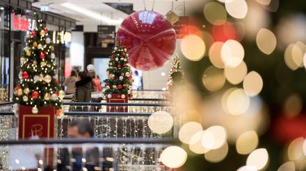Kunden gehen durch ein weihnachtlich geschmücktes Einkaufszentrum in Berlin-Mitte.