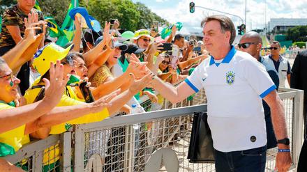 Brazilian President Jair Bolsonaro greets supporters in front of the Planalto Palace, after a protest against the National Congress and the Supreme Court, in Brasilia, on March 15, 2020. (Photo by Sergio LIMA / AFP)