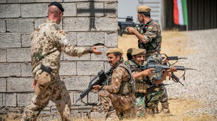 Ein Bundeswehrsoldat und kurdische Peschmerga-Kämpfer im nordirakischen Erbil.