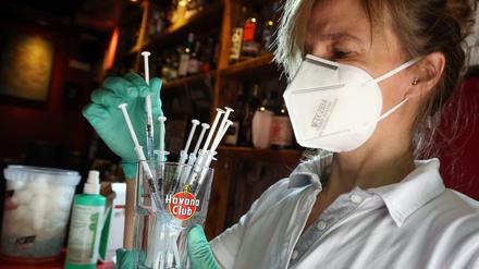 Eine medizinische Fachangestellte sortiert in der Revolte-Bar im Berliner Bezirk Friedrichshain Spritzen mit dem Impfstoff Johnson &amp; Johnson 