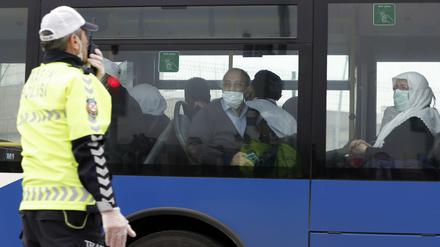 Pilger sitzen am 15.03.2020 in einem Bus, der sie vom Flughafen zu Studentenwohnheimen außerhalb Ankaras gebracht hat, wo sie unter Quarantäne gestellt werden sollen.