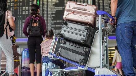 Reisende stehen an den Schaltern in einer der Abfertigungshallen eines Flughafens. (Symbolbild)