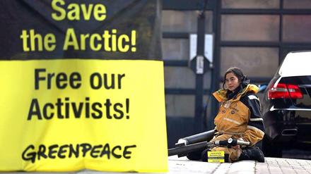 Eine Greenpeace-Aktivistin demonstriert vor einer Tankstelle in Berlin.
