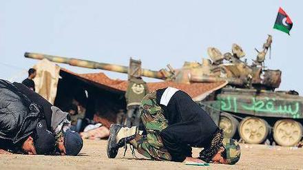 Beten für den Erfolg. Libysche Rebellen, schlecht trainiert und mangelhaft ausgestattet, an der Frontlinie nahe der Stadt Brega. 