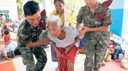 Zivilisten in Not. Thailändische Soldaten helfen einem Dorfbewohner. Foto: dpa