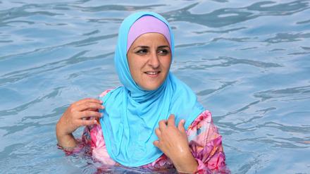 Eine Frau schwimmt im Burkini in einem Berliner Bad.