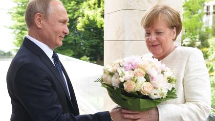 Wladimir Putin überreicht Angela Merkel bei einem Treffen in Sotschi einen Blumenstrauß. 