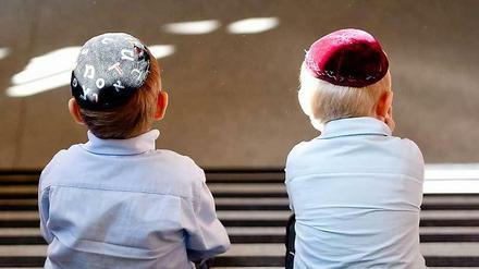 Zwei Jungen sitzen vor der Talmud-Tora-Schule in Hamburg. Für gläubige Juden ist die Kippa ein wichtiges Symbol ihrer Erfurcht vor Gott.