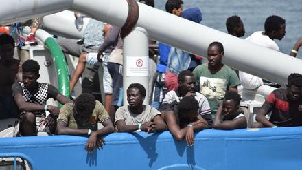 Migranten stehen an Bord eines schwedischen Marineschiffs im Hafen von Catania.