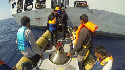 Die italienische Marine nimmt Bootsflüchtlinge auf.