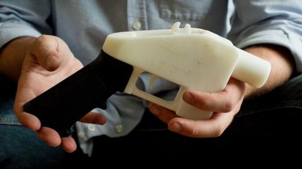  Eine Person hält eine Plastik-Pistole, die komplett im 3D-Drucker hergestellt wurde.