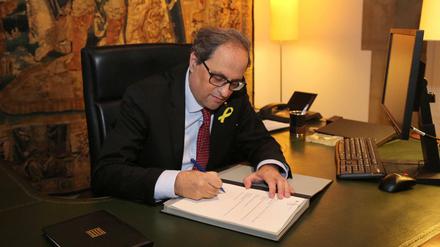 Der katalanische Regionalpräsident Quim Torra unterschreibt ein Dokument. Torra hat mehrere Ministerposten neu besetzt und damit offenbar die Blockade bei der Regierungsbildung in der Krisenregion gelöst. 