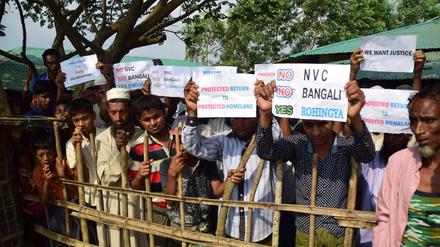 Rohingya-Flüchtlinge halten beim Besuch der UN-Vertreter Plakate hoch.