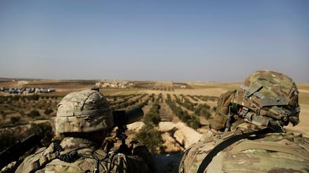 Zwei US-Soldaten schauen von ihrer Basis in Syrien zur türkischen Grenze hinüber. Trump will die US-Truppen abziehen.