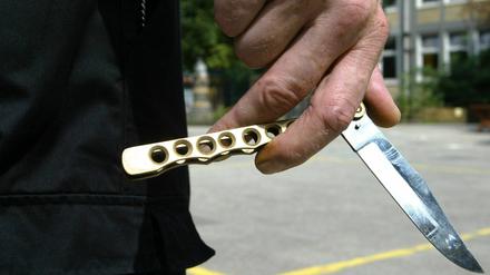 Straftäter hält ein Butterflymesser in der Hand (Symbolbild).