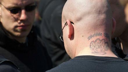 Ein Neonazi-Skinhead mit einem Tattoo eines Schlagrings. Das Kürzel "C18" steht für die Neonazi-Gruppe Combat 18.