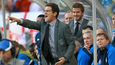 Englands Trainer Fabio Capello gibt lautstark Anweisungen, sein Assistent David Beckham im Hintergrund findet's offenbar amüsant.