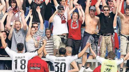 Party mit Fremden. Die Fans des 1. FC Kaiserslautern feiern den Aufstieg in Frankfurt mit der Mannschaft des FSV, die dem FC Augsburg ein Unentschieden abtrotzte. Foto: dpa