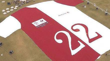 Nummer 22 liegt. Ein riesiges Trikot wirbt für Katars WM-Bewerbung. Foto: AFP