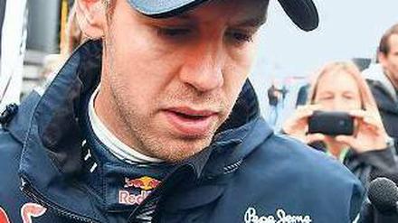 Trübe Gasse. Ein enttäuschter Sebastian Vettel bahnt sich nach dem vierten Platz auf dem Nürburgring seinen Weg durch die Menschenmenge. Foto: dpa
