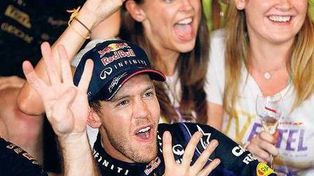Vier Finger für ein Halleluja. Sebastian Vettel jubelt nach seinem Sieg beim Großen Preis von Indien im Kreise seines Teams Red Bull über seinen vierten Weltmeistertitel hintereinander. Foto: dpa