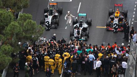 Lewis Hamilton (Mitte) springt aus dem Wagen und lässt sich für seinen Sieg in Monaco feiern.