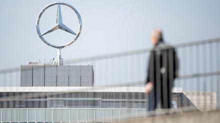 Ein Mitarbeiter von Daimler geht am Mercedes-Benz Werk Untertürkheim zum Schichtwechsel.