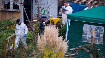 Kriminaltechniker durchsuchen am Freitag eine Gartenlaube in einer Kleingartensiedlung in Luckenwalde.
