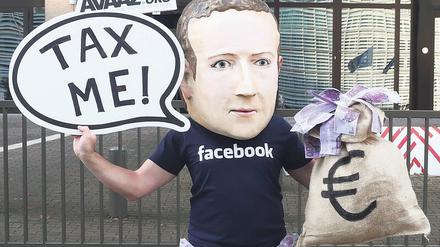 Zahl’ Steuern! Die Aufforderung des Aktivisten mit Zuckerberg-Maske an die global operierenden Onlinekonzerne gilt europaweit.