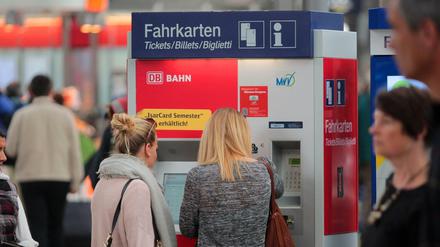 Zwei Frauen stehen an einem Fahrkartenautomat der Deutschen Bahn. 