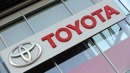 Das Logo des Automobilherstellers Toyota am Gebäude eines Händlers in München. 