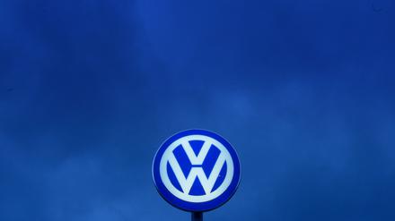 Das VW-Logo leuchtet am Abendhimmel über dem Werkstor von Volkswagen in Wolfsburg.