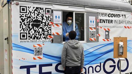 Ein Mann lässt sich an einer mobilen Station in München auf Corona testen.