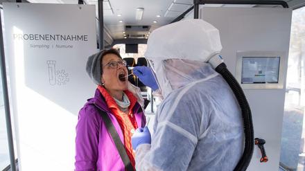 Bei einer Frau wird in einer Teststation in Neu-Ulm ein Abstrich genommen.