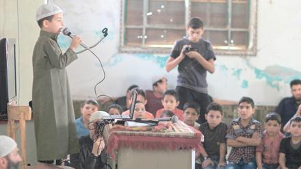 Hochkonzentriert. Ein Junge rezitiert den Koran bei einem Lernwettbewerb. Das Foto entstand 2016 in einem Vorort von Damaskus in Syrien.
