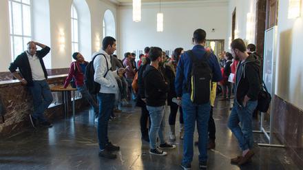 Studierende stehen im Foyer eines Unigebäudes.