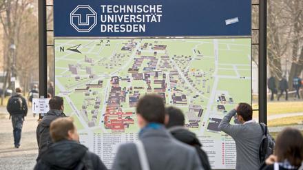 Studierende stehen vor einem Lageplan der TU Dresden.